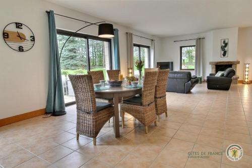 une salle à manger et un salon avec une table et des chaises dans l'établissement Le petit be, à Pluduno