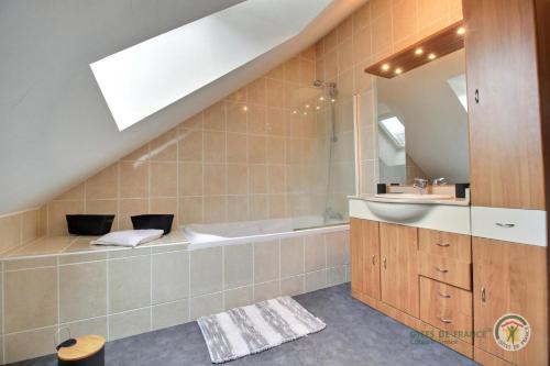 une salle de bain avec une baignoire et un lavabo dans l'établissement Le petit be, à Pluduno