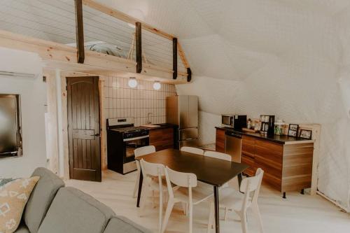 a living room with a table and a kitchen at Moonshine Hollow Dome By Rafting in Cosby
