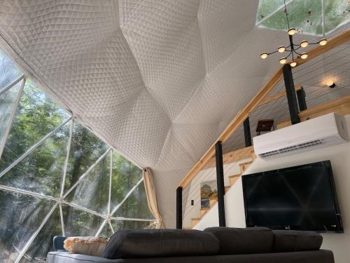 a living room with a couch and a large window at Moonshine Hollow Dome By Rafting in Cosby