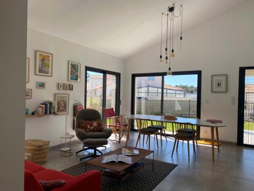 un salon avec une table et des chaises dans l'établissement Maison moderne et charmante à 450m de la plage, 2 chambres, terrasse et barbecue - FR-1-336-153, à Saint-Vincent-sur-Jard