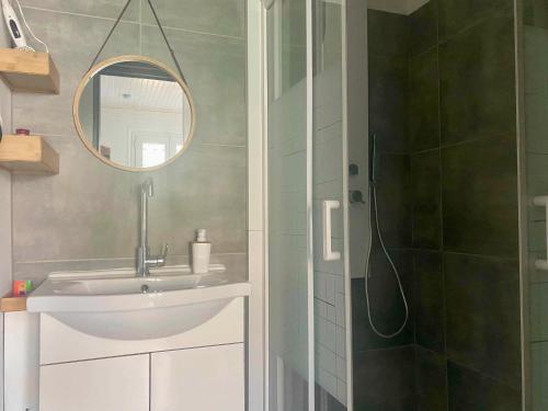 une salle de bain avec un lavabo et une douche avec un miroir dans l'établissement Pavillon rénové avec terrasse privative au cœur de Jard-sur-Mer, proche plages et port - FR-1-336-155, à Jard-sur-Mer