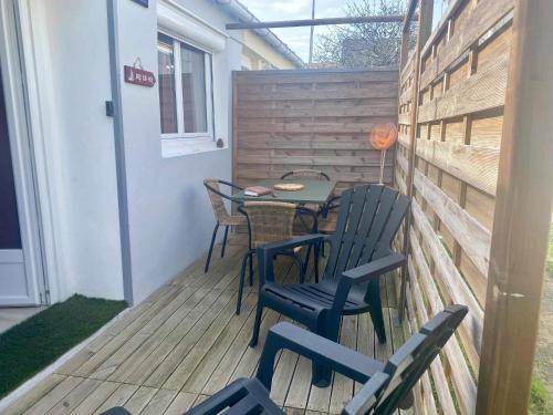 un patio avec une table et des chaises sur une terrasse dans l'établissement Pavillon rénové avec terrasse privative au cœur de Jard-sur-Mer, proche plages et port - FR-1-336-155, à Jard-sur-Mer