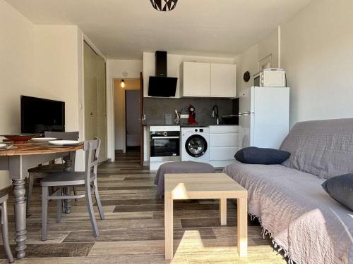 un salon et une cuisine avec un canapé et une table dans l'établissement Appartement Coquet à Collioure, Proche Plage, Parking Privatif, Animaux Acceptés, Ménage Inclus - FR-1-225-817, à Collioure