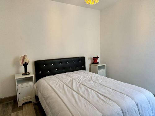- une chambre avec un lit avec deux tables et un chat dans l'établissement Appartement Coquet à Collioure, Proche Plage, Parking Privatif, Animaux Acceptés, Ménage Inclus - FR-1-225-817, à Collioure