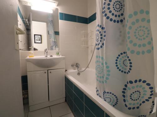 une salle de bain avec un lavabo et un rideau de douche dans l'établissement Sète: T2 avec terrasse couverte, piscine et parking en résidence front de mer - FR-1-472A-306, à Sète