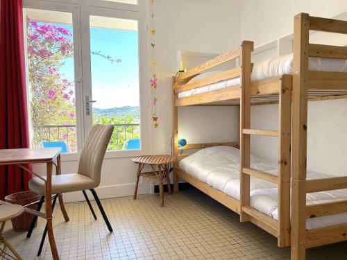 - une chambre avec 2 lits superposés, une table et une chaise dans l'établissement Appartement calme, 500m plage, 4 couchages, parking inclus - Bormes Les Mimosas - FR-1-251-831, à Bormes-les-Mimosas