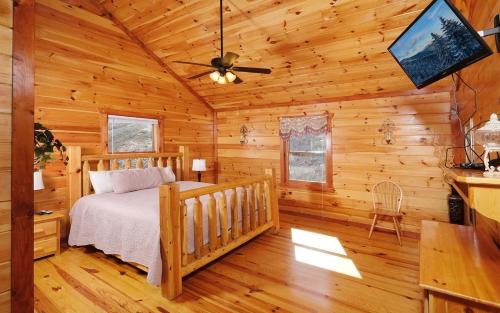 ein Schlafzimmer mit einem Bett in einem Blockhaus in der Unterkunft Jennies Cove in Pigeon Forge