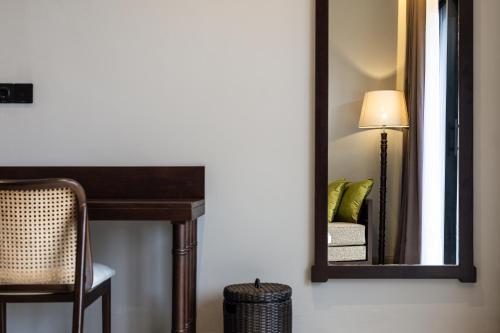 a mirror in a room with a table and a lamp at The Clifton Ubud Valley in Ubud