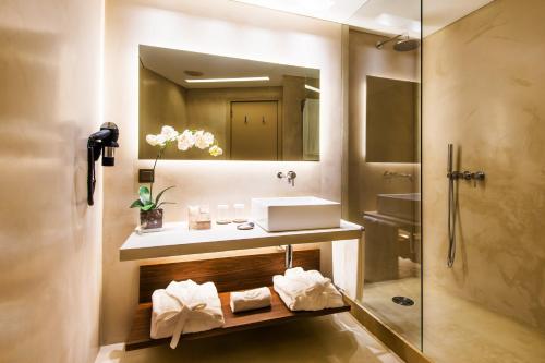 a bathroom with a sink and a mirror at Hotel Dom Henrique - Downtown in Porto