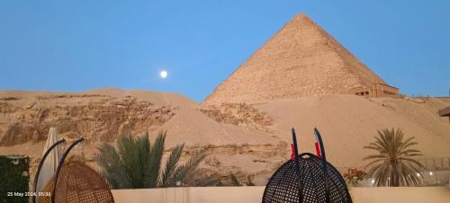 una vista de las pirámides en el desierto con un bolso en Crystal pyramid inn en El Cairo