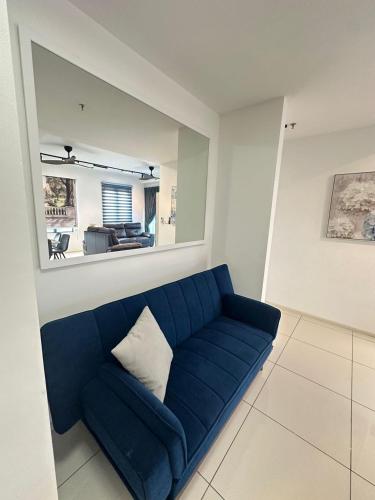 a blue couch in a living room with a mirror at JOMSTAY Sunway Onsen Suites Ipoh - Lost World of Tambun Ipoh Waterpark in Tambun