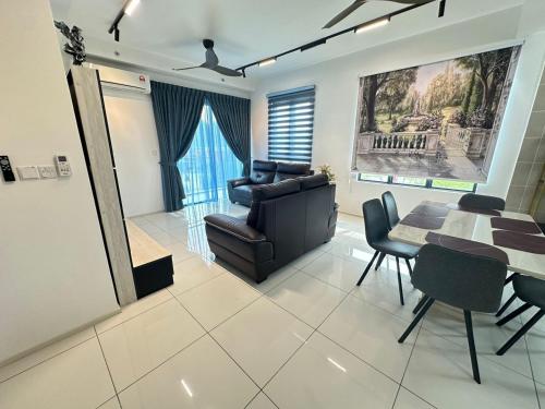 a living room with a table and a chair and a couch at JOMSTAY Sunway Onsen Suites Ipoh - Lost World of Tambun Ipoh Waterpark in Tambun