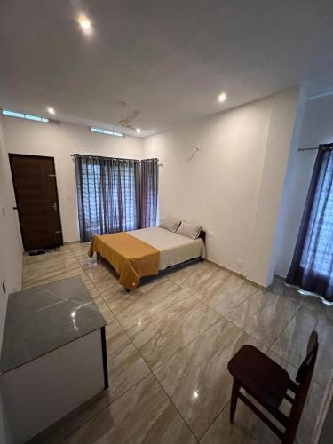 a bedroom with a bed and a table and windows at Willow Nest in Anachal