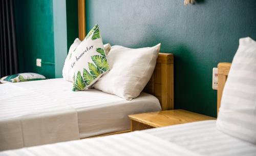 a hotel room with two beds and a pillow on the bed at VietHouse Homestay Ha Long in Ha Long