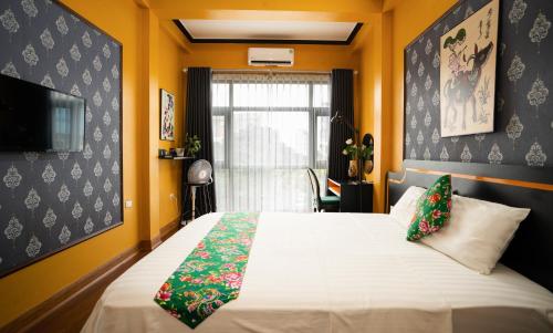 a bedroom with a bed and a window and a television at VietHouse Homestay Ha Long in Ha Long