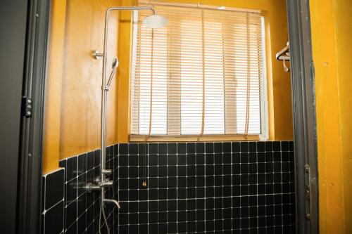 a bathroom with a shower and black tile at VietHouse Homestay Ha Long in Ha Long
