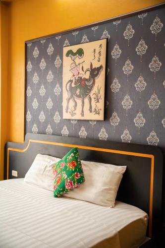 a bedroom with a bed with a painting on the wall at VietHouse Homestay Ha Long in Ha Long