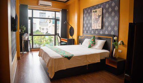 a bedroom with a bed and a large window at VietHouse Homestay Ha Long in Ha Long
