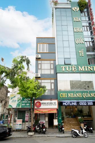 a building on a city street with motorcycles parked in front at VietHouse Homestay Ha Long in Ha Long