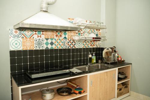 a kitchen with a sink and a tile wall at VietHouse Homestay Ha Long in Ha Long