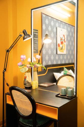 a desk with a lamp and a table with a mirror at VietHouse Homestay Ha Long in Ha Long