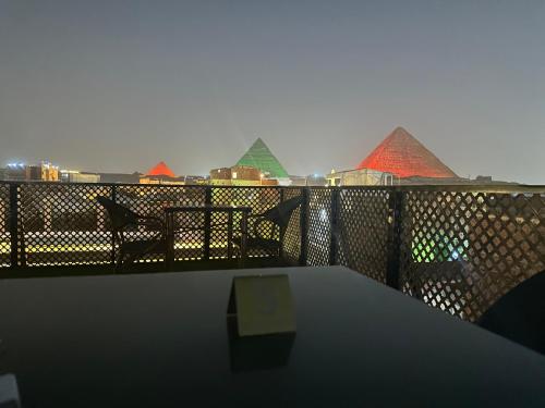 una mesa en un balcón con vistas a las pirámides en Nefertari pyramids inn, en El Cairo