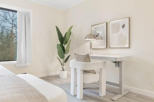 a white bedroom with a desk and a chair at Bellevue Modern Luxe Townhouse near DT 520 I405 in Bellevue
