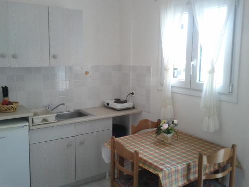 una cucina con tavolo, lavandino, tavolo e sedie di Villa Stefania ad Acharavi