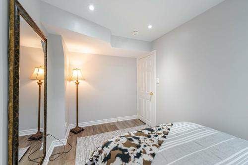 a bedroom with a bed and a mirror at Lovely Cozy Apartment in Brampton