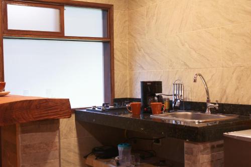 eine Küche mit einem Waschbecken und einem Fenster in der Unterkunft Eco Chalet El Encanto La Calera in La Calera