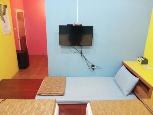 a room with a bed with a tv on the wall at 小琉球陽光藍海民宿 in Xiaoliuqiu
