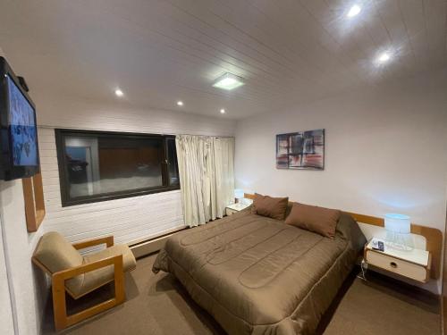 a bedroom with a bed and a large window at Departamento en Edificio Atenas con excelentes Vistas in Las Lenas
