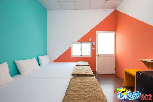 a room with colorful walls and two beds in it at 小琉球陽光藍海民宿 in Xiaoliuqiu