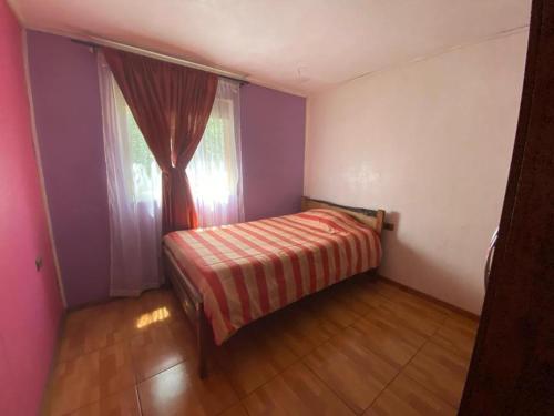 a small bedroom with a bed and a window at Vista verde Llonquén in Liquiñe