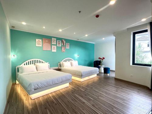 two beds in a bedroom with a green wall at Memory Inn - Valley View in Xuan An
