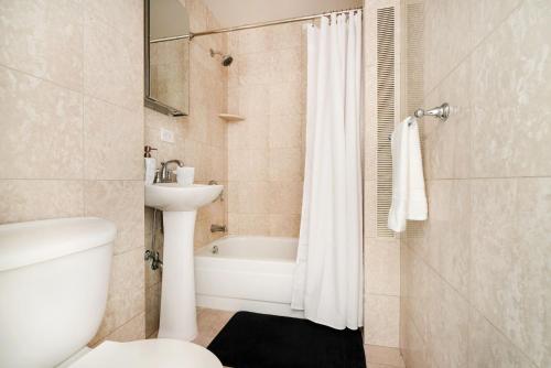 łazienka z wanną, umywalką i toaletą w obiekcie 73-819 New Studio UWS Doorman Gym w Nowym Jorku