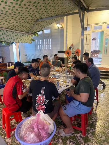 a group of people sitting at a table eating food at Villa homestay Misa in Phan Thiet