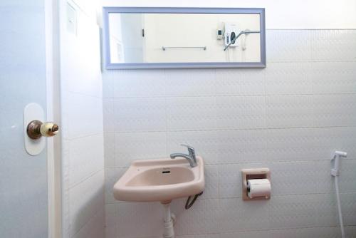 a bathroom with a sink and a mirror on the wall at Jessa's 5 Guests house in Moalboal