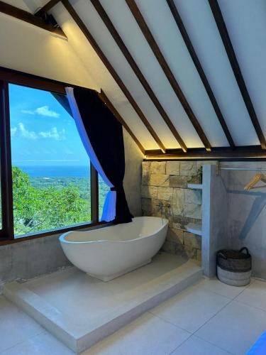 a large bath tub in a room with a window at Divinity Villas - Uluwatu, Bali in Uluwatu