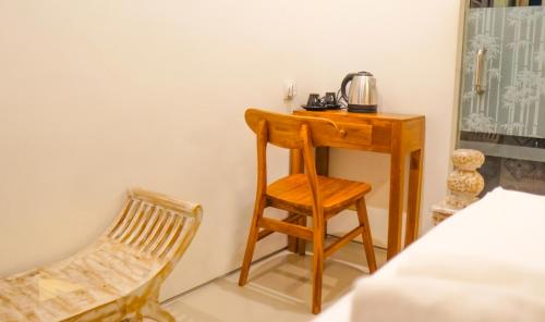 a wooden desk and a chair in a room at Dirga's House Sanur View by EPS in Sanur