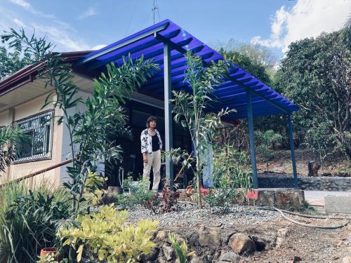 a woman standing in the doorway of a house at The poolhouse at McKirdy's mango farm in Sison