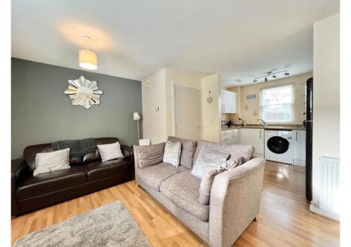 a living room with a couch and a table at 1 Captain's Rest Modern 2 bedroom Brixham harbour flat in Brixham