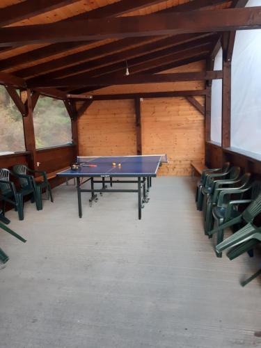 a ping pong table in a room with chairs at Cabana Valea Arieșului in Arieşeni