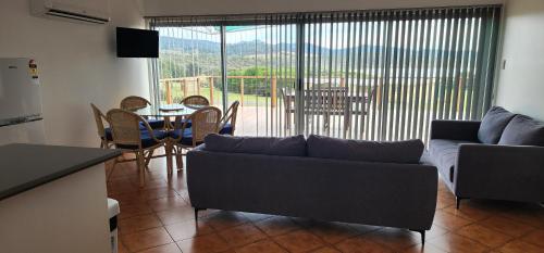 a living room with a couch and a table and chairs at White Sands Estate in Falmouth