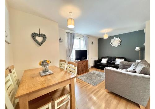 a living room with a table and a couch at 1 Captain's Rest Modern 2 bedroom Brixham harbour flat in Brixham