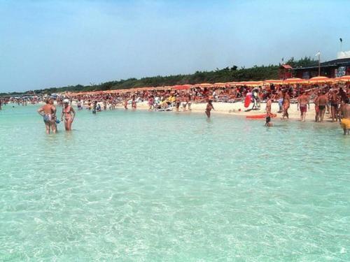 a group of people standing in the water at a beach at Casa Mandorle in Ugento