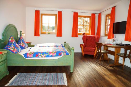a bedroom with a bed and a table and a chair at Seehotel und Appartements Schnöller in Rieden am Forggensee