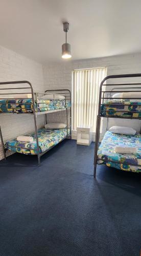 a room with three bunk beds and a window at White Sands Estate in Falmouth
