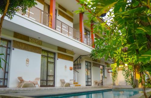 an exterior view of a building with a swimming pool at Dirga's House Sanur View by EPS in Sanur